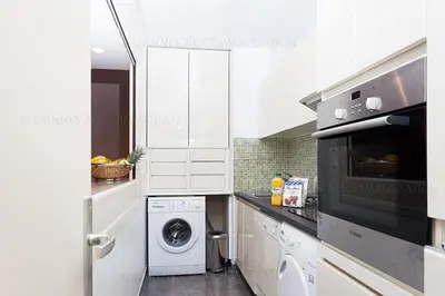 a white kitchen with a washer and dryer in it at gray 3a2 in Cannes