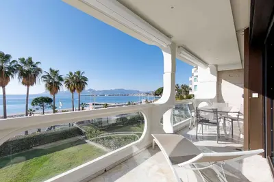 a balcony with a view of the ocean and palm trees at Louis 2 in Cannes