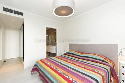a bedroom with a bed with a colorful striped blanket at Louis 2 in Cannes