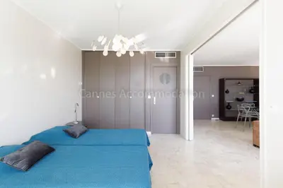 a bedroom with a blue bed in a white room at Louis 2 in Cannes