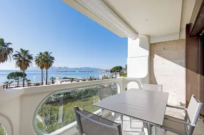 a table and chairs on a balcony with a view of the beach at Louis 2 in Cannes
