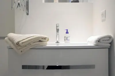 a bathroom with a sink and towels on a shelf at C004-Cosy studio proche la Croisette et le Suquet in Cannes