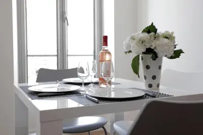 a table with a bottle of wine and a vase of flowers at C004-Cosy studio proche la Croisette et le Suquet in Cannes