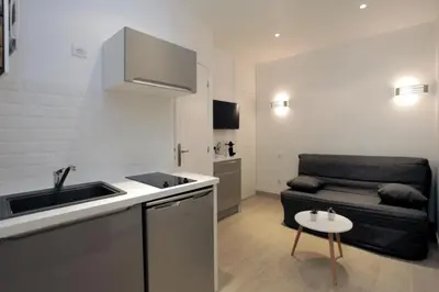 a kitchen with a sink and a couch in a room at C005-Studette au centre Cannes in Cannes