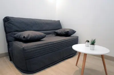 a couch with two pillows on it next to a table at C005-Studette au centre Cannes in Cannes
