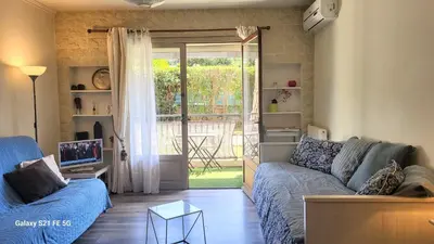 a living room with a couch and a sliding glass door at CANNES STUDIO - wifi, clim in Cannes