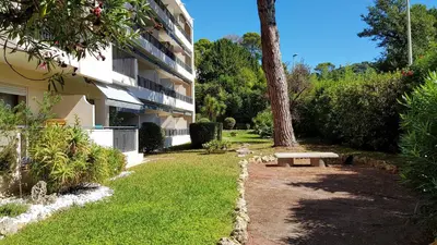 a garden with a bench next to a building at CANNES STUDIO - wifi, clim in Cannes