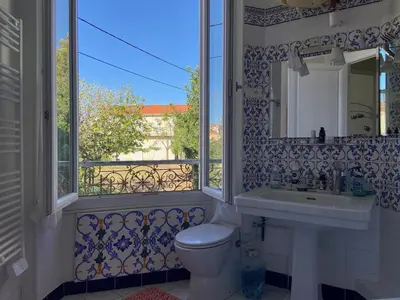 a bathroom with a toilet and a sink and a window at Centre Ville Calme Festivales Plages in Cannes
