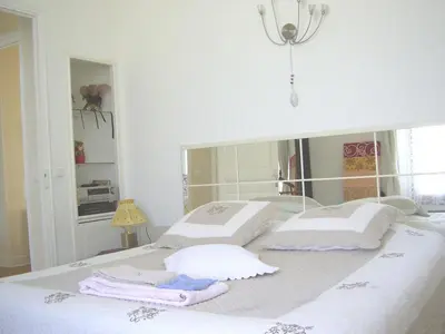 a white bed with three pillows on top of it at Centre Ville Calme Festivales Plages in Cannes