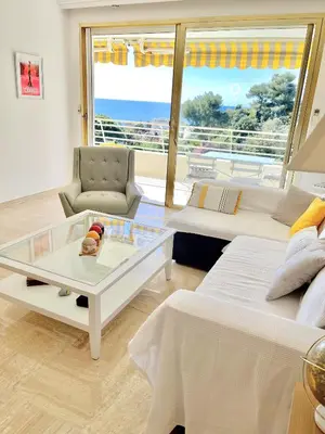 a living room with two beds and a glass table at Solezia appartement, piscine et vue mer, by Welcome to Cannes in Cannes