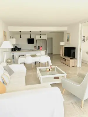 a living room with a white couch and a table at Solezia appartement, piscine et vue mer, by Welcome to Cannes in Cannes
