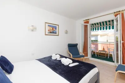 a bedroom with a bed and a chair and a window at Alexandra YourHostHelper in Cannes
