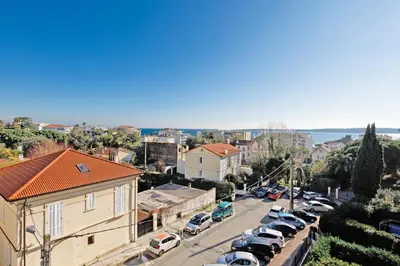 a city street with cars parked in a parking lot at Alexandra YourHostHelper in Cannes