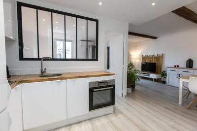 a kitchen with white cabinets and a large window at Le Forville : 400m Palais, Calme, Clim in Cannes
