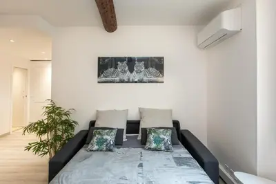 a living room with a bed in a room at Le Forville : 400m Palais, Calme, Clim in Cannes