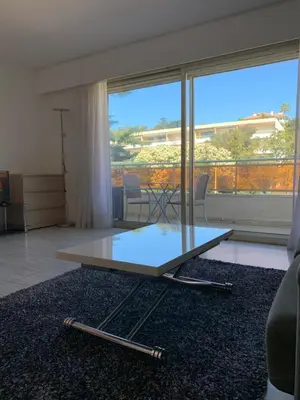 a glass coffee table sitting on a rug in a living room at Cannes Standing proche Croisette in Cannes