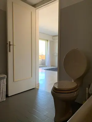 a bathroom with a toilet with a door open at Cannes Standing proche Croisette in Cannes
