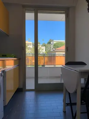a kitchen with a sliding glass door to a balcony at Cannes Standing proche Croisette in Cannes