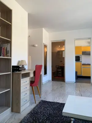 a kitchen with a desk and a red chair in a room at Cannes Standing proche Croisette in Cannes