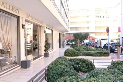 a store front with bushes in front of a building at Beautiful studio at the Grand Hotel Residence with sunny balcony 138 in Cannes