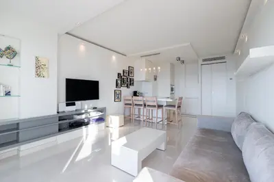 a white living room with a couch and a tv at Agence des Résidences - Appartements privés du 45 CROISETTE- Prestige in Cannes