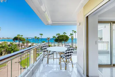 a balcony with a table and chairs and a view of the ocean at Agence des Résidences - Appartements privés du 45 CROISETTE- Prestige in Cannes