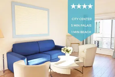 a living room with a blue couch and white chairs at 2-Br City center near Croisette & Palais in Cannes