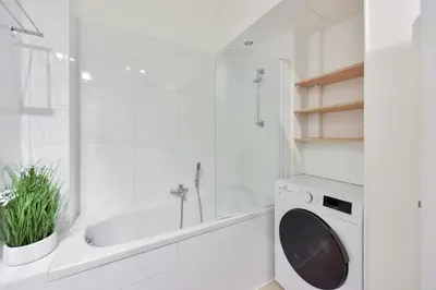 a white bathroom with a tub and a washing machine at 2-Br City center near Croisette & Palais in Cannes