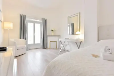 a white bedroom with a bed and a desk at 2-Br City center near Croisette & Palais in Cannes