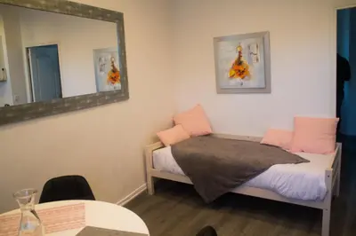 a bedroom with a bed with a mirror and a table at Appartement palais plages in Cannes