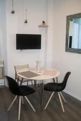 a table and chairs in a room with a tv at Appartement palais plages in Cannes