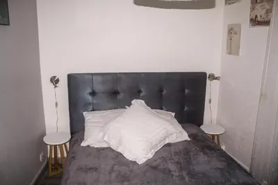 a bed with a black headboard and a white pillow at Appartement palais plages in Cannes