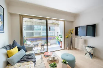 a living room with a couch and a large window at Magnifique 3 pièces en plein cœur de Cannes in Cannes