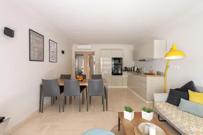 a living room and kitchen with a table and chairs at Magnifique 3 pièces en plein cœur de Cannes in Cannes