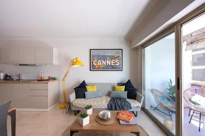 a living room with a couch and a table at Magnifique 3 pièces en plein cœur de Cannes in Cannes