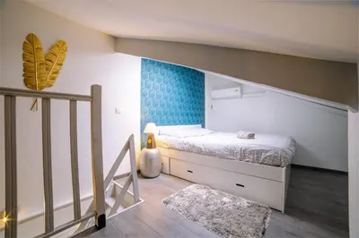 a small bedroom with a bed and a staircase at Ô Station Cannes Apartment in Cannes