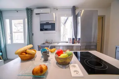 a kitchen with baskets of fruits and vegetables on a counter at Ô Station Cannes Apartment in Cannes