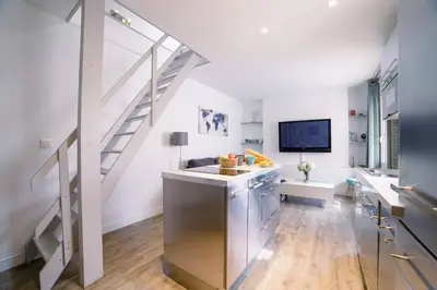 a kitchen with a staircase and a living room at Ô Station Cannes Apartment in Cannes