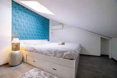 a bedroom with a bed and a blue wall at Ô Station Cannes Apartment in Cannes