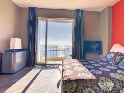 a bedroom with a bed and a large window at Un Palais au prix d'un 3 étoiles in Cannes