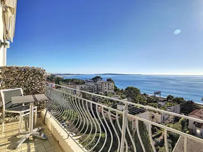 a balcony with a chair and a view of the ocean at Un Palais au prix d'un 3 étoiles in Cannes