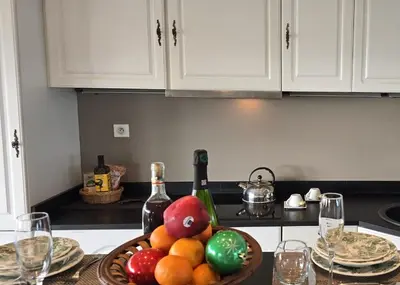 a kitchen counter with a bowl of fruit and wine bottles at 