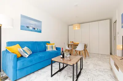 a living room with a blue couch and a table at All Blue YourHostHelper in Cannes