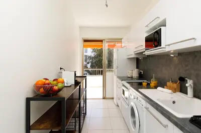 a kitchen with white appliances and a counter with a bowl of fruit at All Blue YourHostHelper in Cannes