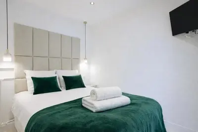 a bedroom with a large white bed with green pillows at Luxury Maubourg - Vue mer - Croisette 50m plage - Clim - terrasse in Cannes