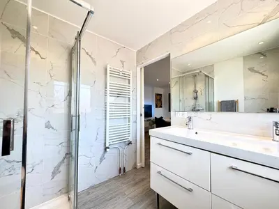 a white bathroom with a sink and a shower at Le Saint-Jean By SCLS Locations in Cannes