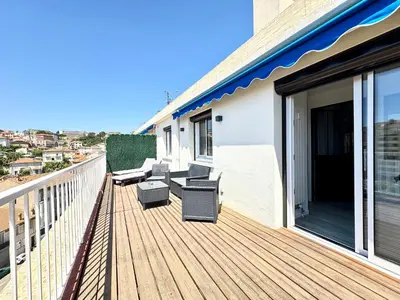 a wooden deck with chairs and tables on a building at Le Saint-Jean By SCLS Locations in Cannes