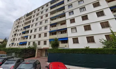 a large white building with cars parked in a parking lot at Le Saint-Jean By SCLS Locations in Cannes