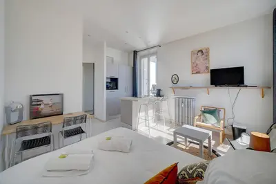 a living room with a bed and a room with a tv at IMMOGROOM - Bourgeois building - Quiet - Parking - Sea view in Cannes