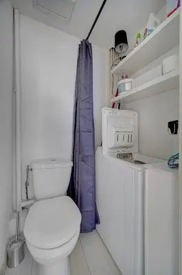 a bathroom with a white toilet and a washer and dryer at IMMOGROOM - Bourgeois building - Quiet - Parking - Sea view in Cannes